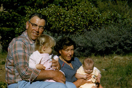 Grandpa sitting with Karen in his lap with Grandma holding Donald up at Tahoe.